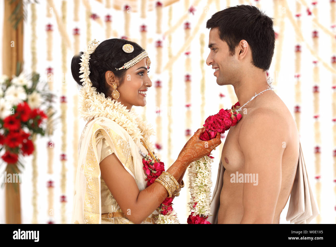 Indian paio di eseguire la Mala Badal nella cerimonia di nozze mandap Foto Stock Indian paio di eseguire la Mala Badal nella cerimonia di nozze mandap Foto Stock