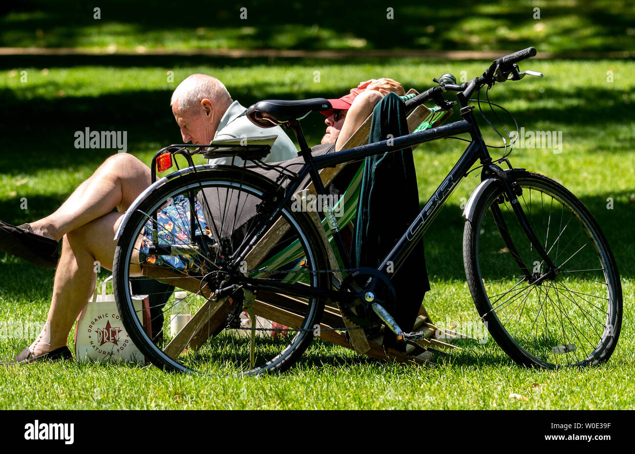 Londra. Il 27 giugno 2019. Regno Unito: Meteo Sole in Green Park, Londra Credito: giovane sulla sdraio con bike Ian Davidson/Alamy Live News Foto Stock