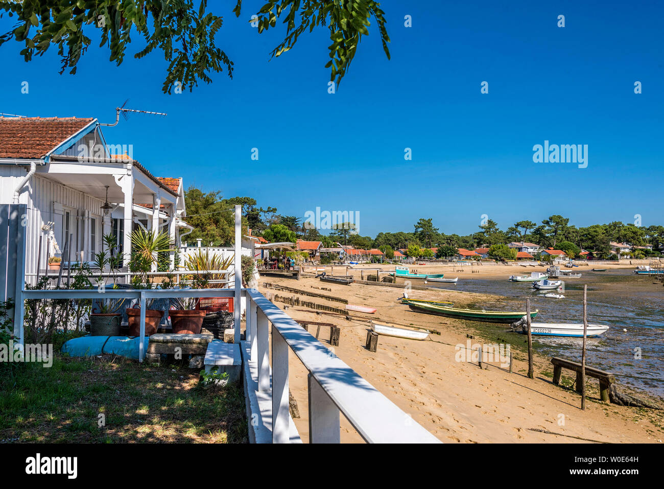 Francia, Gironde, Baia di Arcachon, Cap-Ferret, Canon oyster village, case lungo la spiaggia e le barche con messa a terra a bassa marea Foto Stock