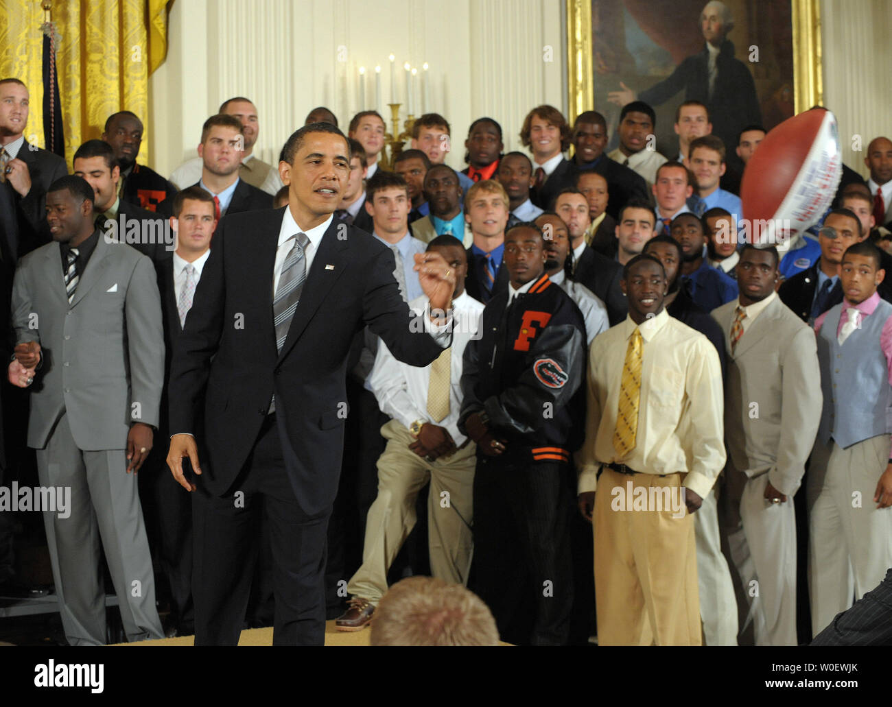 Stati Uniti Il presidente Barack Obama lancia il calcio, a lui presentati dall'Università di Florida Gators football team, che si è congratulato con lui per la conquista del 2009 BCS Campionato Nazionale, a un assistente nella Sala Est della Casa Bianca a Washington il 23 aprile 2009. (UPI foto/Roger L. Wollenberg) Foto Stock