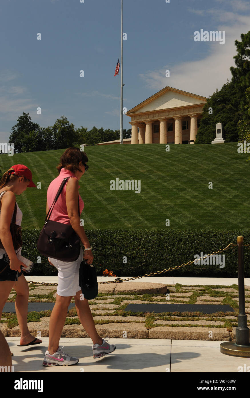 Visitatori visualizza le tombe del Presidente John F. Kennedy e Jacqueline Kennedy Onassis davanti alla fiamma eterna presso il Cimitero Nazionale di Arlington in Arlington, Virginia, il 11 agosto 2009. Dietro il luogo di sepoltura è casa di Arlington, Robert E. Lee home, in cui il flag vola a metà del personale. Eunice Kennedy Shriver, Presidente Kennedy e la sorella di fondatore della Special Olympics, è morto oggi all'età di 88. UPI/Roger L. Wollenberg Foto Stock