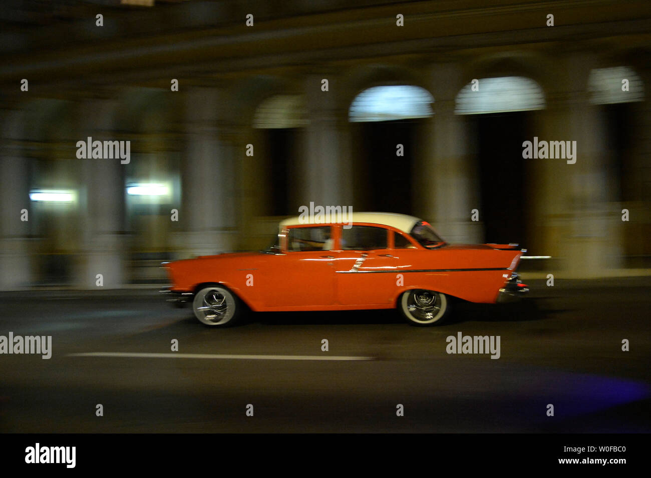 Cuba, La Habana, un vecchio orange americano auto da 50's va di notte a piena velocità Foto Stock