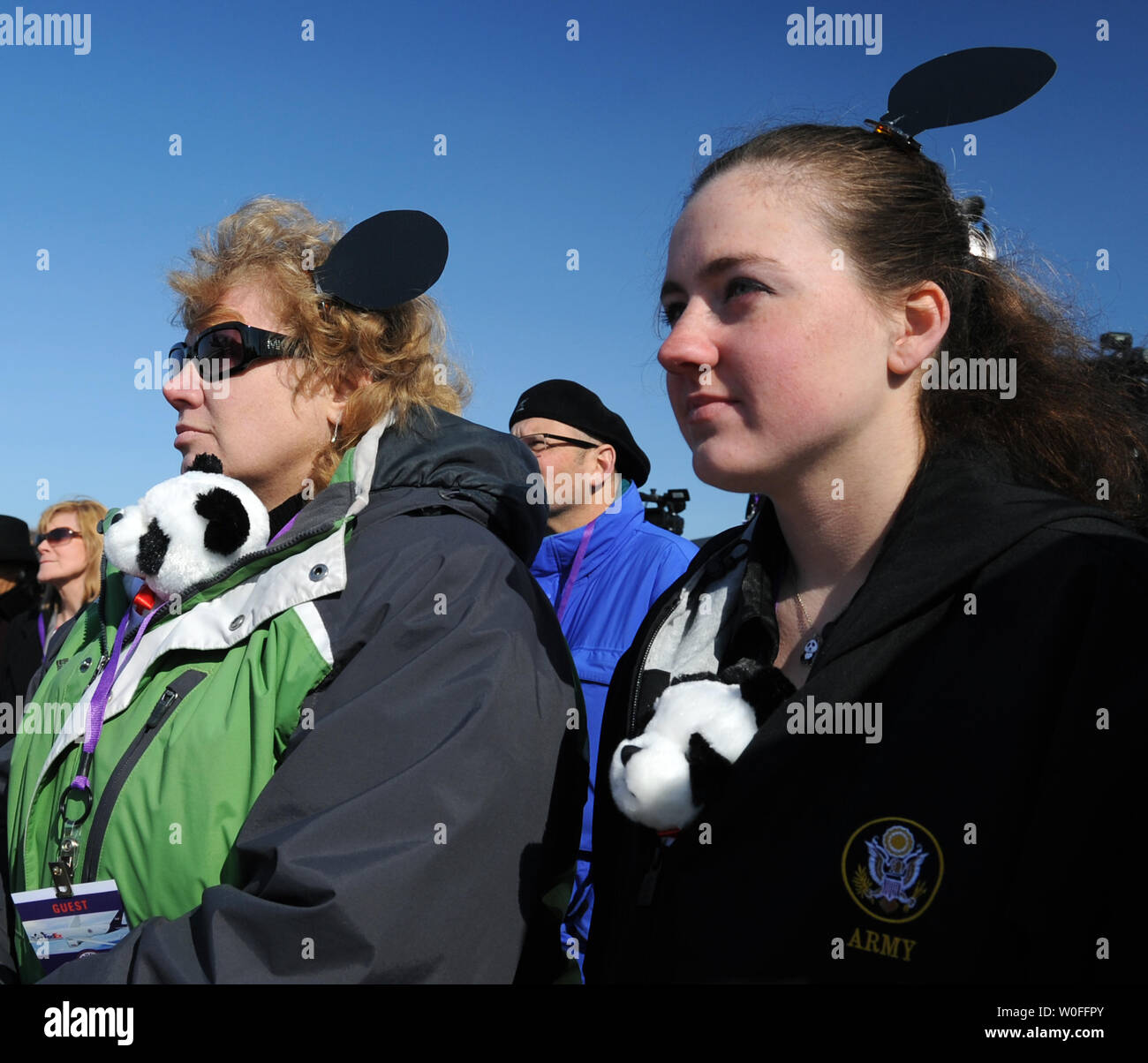 Donne che indossano ripiene e Panda Panda orecchie guarda come Tai Shan, un bambino di 4 anni maschio panda gigante, viene spostato in un FedEx Express 777 cargo aereo all'Aeroporto di Dulles a Dulles, Virginia il 4 febbraio 2010. Tai Shan e un altro di 3 anni panda femmina, Mei Lan, dallo Zoo di Atlanta, sarà trasportato sulla "FedEx Panda Express' a Chengdu, in Cina per entrare a far parte del paese allevamento e programma di conservazione. Entrambi i panda sono di proprietà del governo cinese e sono state affittate a gli Stati Uniti. UPI/Alexis C. Glenn. Foto Stock