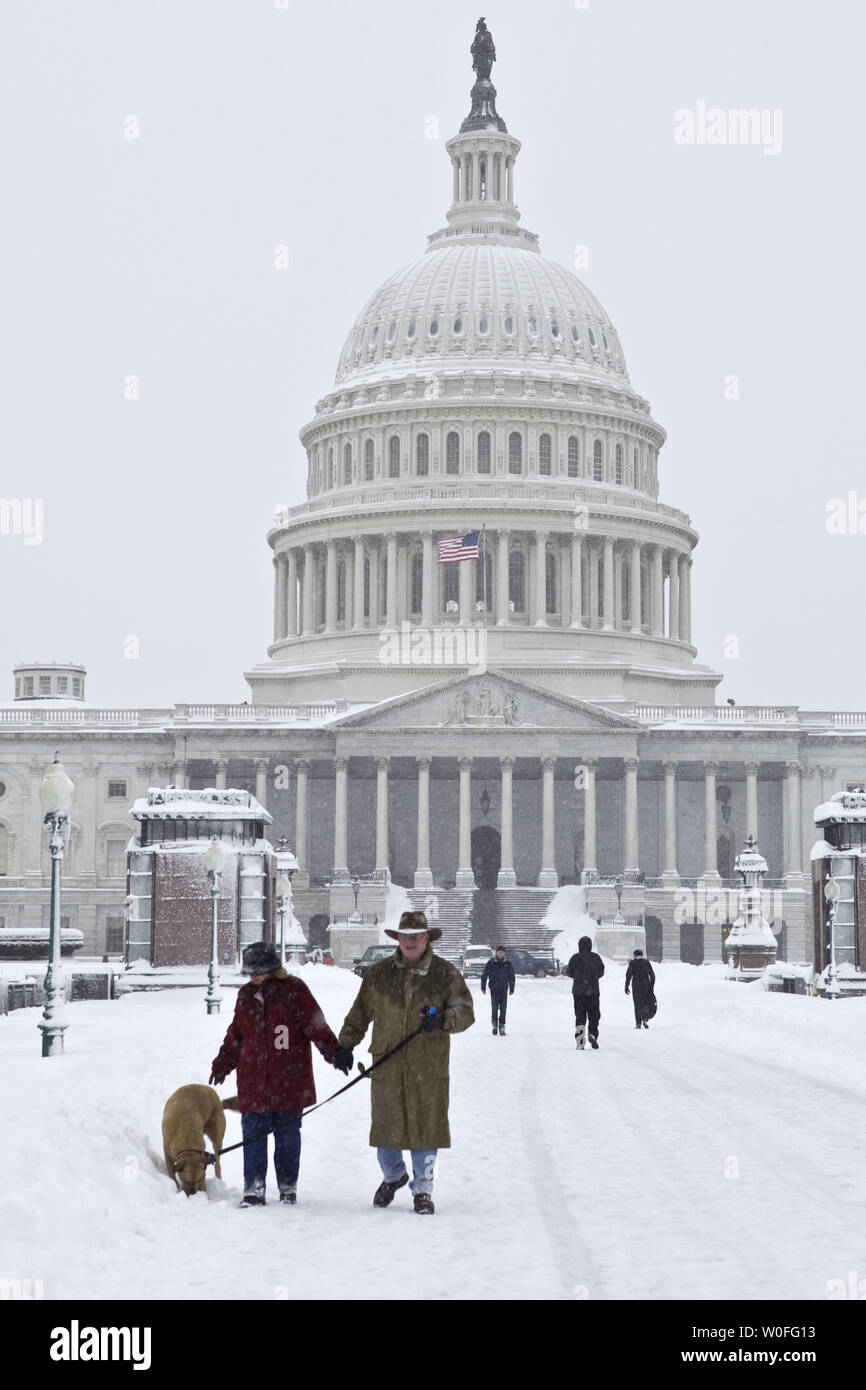 DC residenti a piedi il loro cane di fronte al Campidoglio di Washington il 6 febbraio 2010 dopo la neve caduta. La tempesta di neve è previsto per essere il più grande della Capitale della Nazione ha visto. UPI/Madeline Marshall Foto Stock