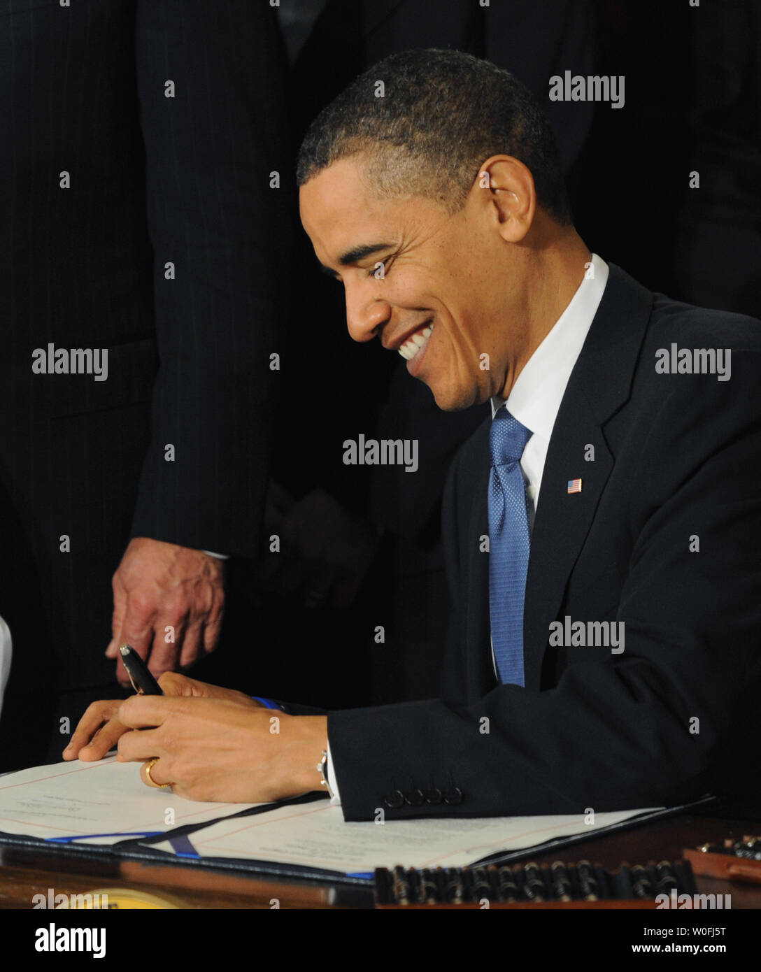 Stati Uniti Il presidente Barack Obama sorrisi come lui firma l'assicurazione sanitaria disegno di legge di riforma nella Sala Est della Casa Bianca di Washington il 23 marzo 2010. Il centro storico di $938 milioni di health care bill sarà garantita la copertura per 32 milioni di americani non assicurati e toccherà quasi ogni americano la vita. UPI/Pat Benic Foto Stock