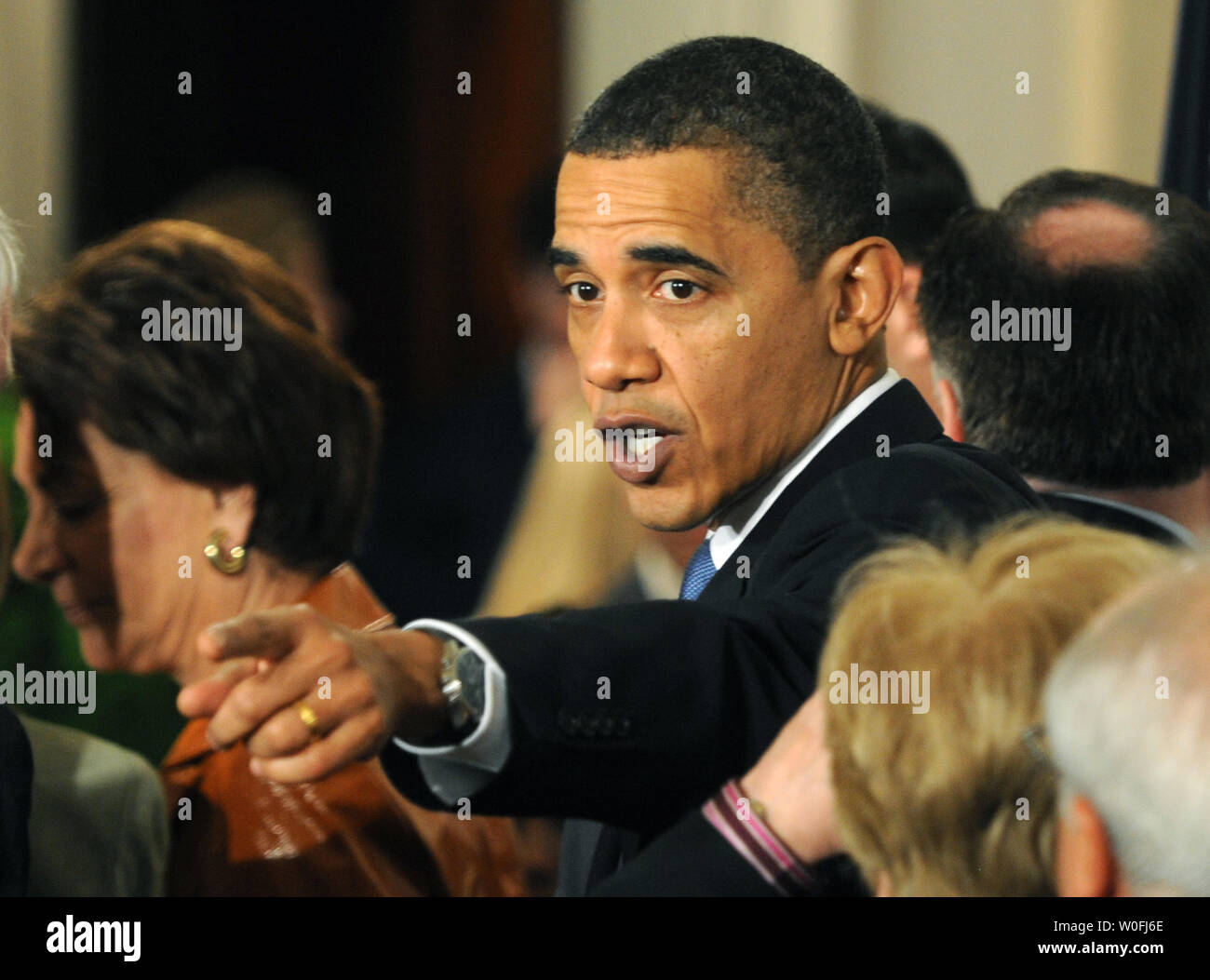 Stati Uniti Il presidente Barack Obama riconosce qualcuno del pubblico dopo che aveva firmato l'assicurazione sanitaria disegno di legge di riforma nella Sala Est della Casa Bianca di Washington il 23 marzo 2010. Il centro storico di $938 milioni di health care bill sarà garantita la copertura per 32 milioni di americani non assicurati e toccherà quasi ogni americano la vita. UPI/Pat Benic Foto Stock