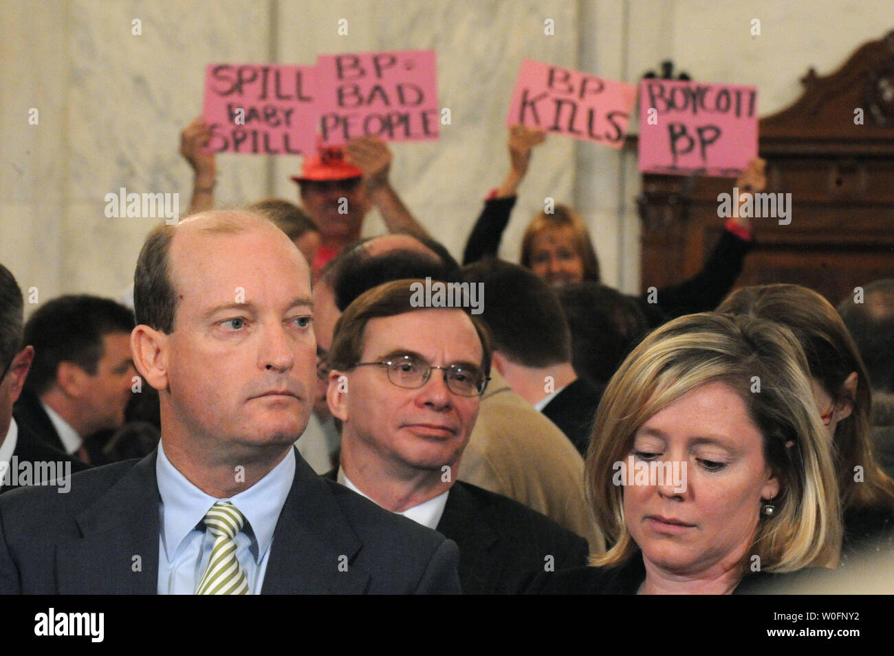 Lamar McKay (L), Presidente e Presidente di BP America Inc., attende per testimoniare come i manifestanti tenere cartelli contro la BP durante un senato di energia e di risorse naturali audizione del Comitato BP Deepwater Horizon oil rig incidente nel Golfo del Messico, a Washington il 11 maggio 2010. UPI/Kevin Dietsch Foto Stock