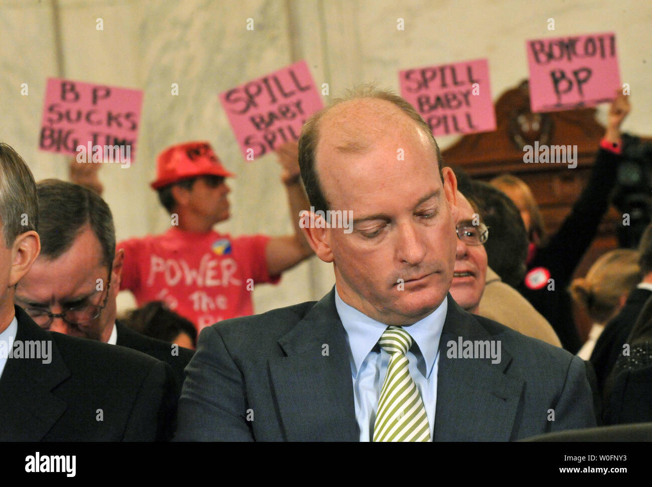 Lamar McKay, Presidente e Presidente di BP America Inc., attende per testimoniare come i manifestanti tenere cartelli contro la BP durante un senato di energia e di risorse naturali audizione del Comitato BP Deepwater Horizon oil rig incidente nel Golfo del Messico, a Washington il 11 maggio 2010. UPI/Kevin Dietsch Foto Stock
