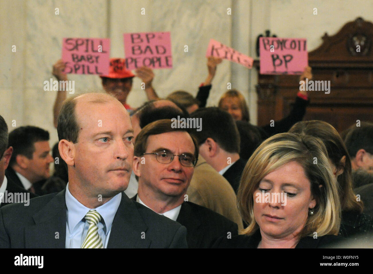 Lamar McKay (L), Presidente e Presidente di BP America Inc., attende per testimoniare come i manifestanti tenere cartelli contro la BP durante un senato di energia e di risorse naturali audizione del Comitato BP Deepwater Horizon oil rig incidente nel Golfo del Messico, a Washington il 11 maggio 2010. UPI/Kevin Dietsch Foto Stock