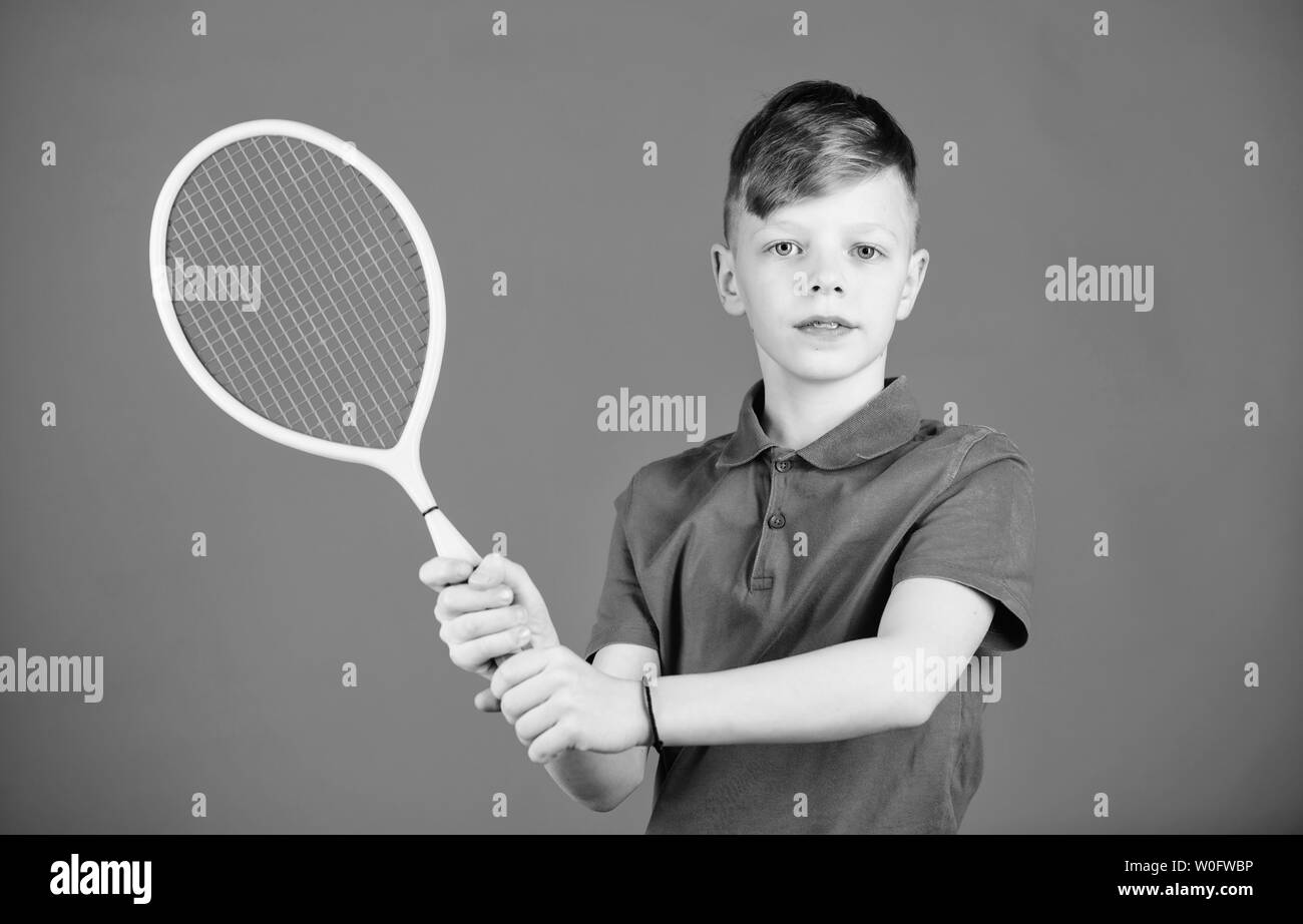 Tennis club. Giocatore di tennis con la racchetta. Attività dell infanzia. Little Boy. Dieta Fitness porta Salute ed energia. Palestra di allenamento di teen boy. Gioco di sport di successo. Bambino felice a giocare a tennis. Corsi di tennis. Foto Stock