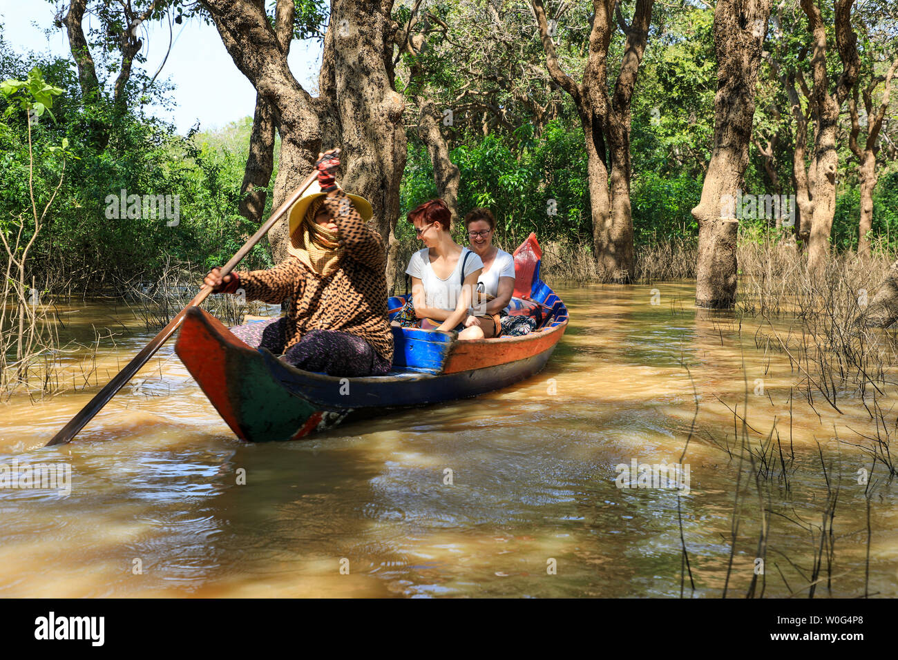 Donne locali canottaggio imbarcazioni turistiche attraverso le paludi di mangrovie su Tonlé Sap River, Tonlé Sap lago, vicino a Siem Reap, Cambogia, sud-est asiatico Foto Stock