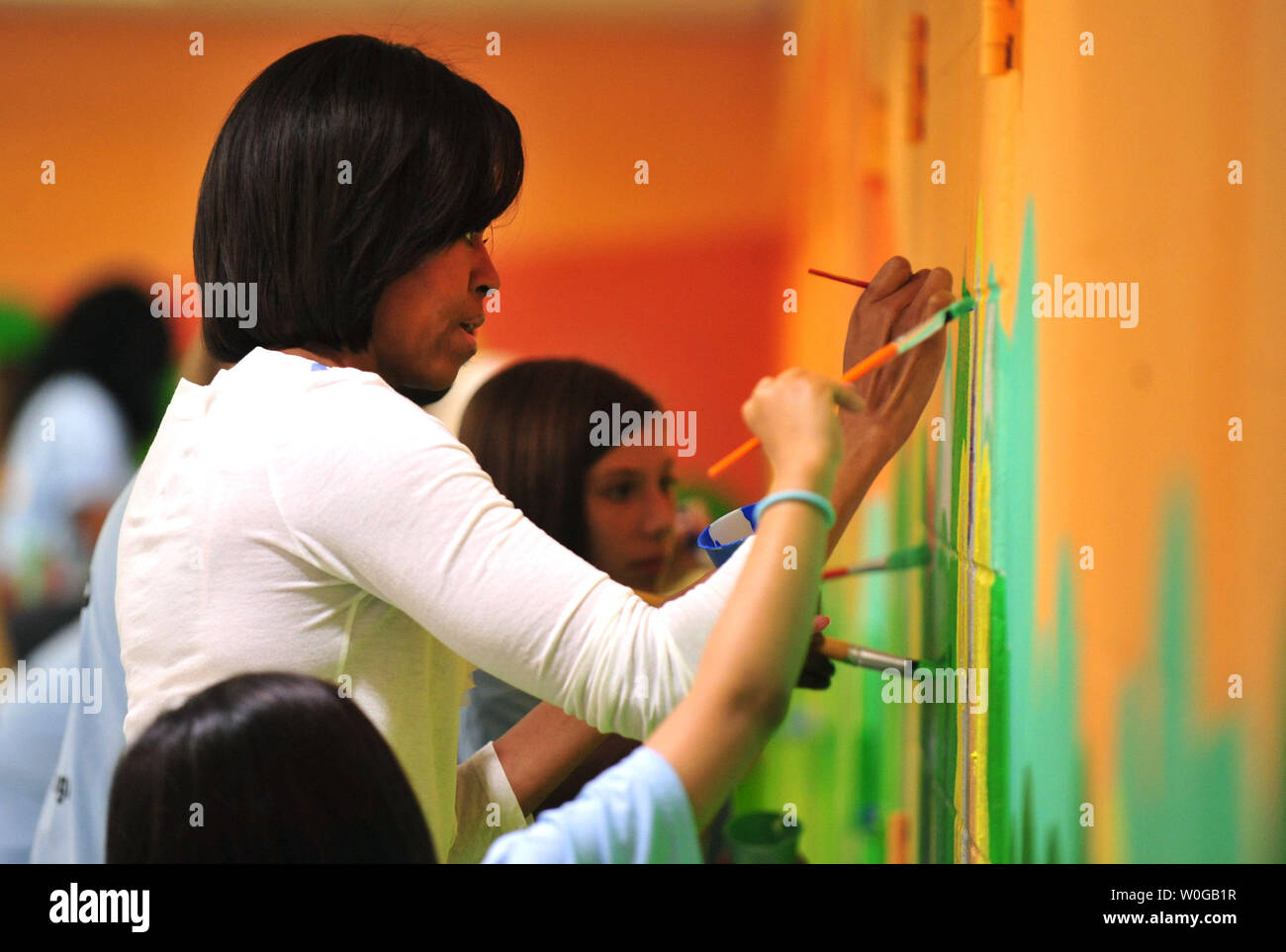 La First Lady Michelle Obama aiuta a dipingere un murale durante una comunità di servizio il giorno di attività a base comune Anacostia-Bolling a Washington il 19 maggio 2011. La First Lady, Congressional coniugi e local area bambini hanno aiutato i banchi di vernice e un murale in corrispondenza della base del centro della gioventù. UPI/Kevin Dietsch Foto Stock