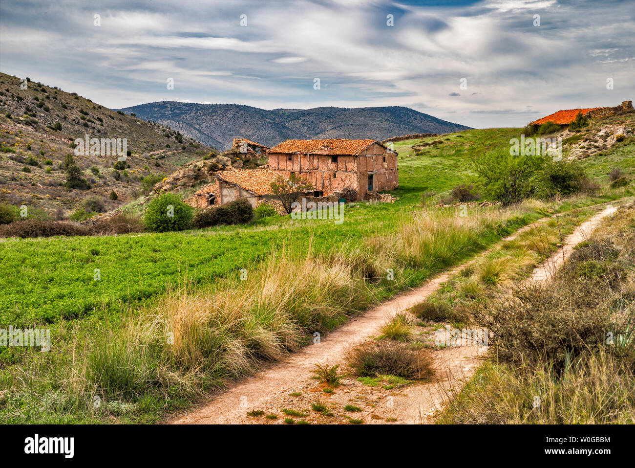 Vecchi edifici agricoli, strada rasata in Sierra de Albarracin, vicino Albarracin, provincia di Teruel, Aragona, Spagna Foto Stock