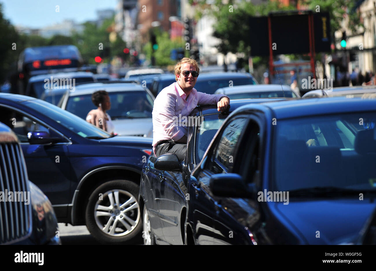 Un passeggero si blocca al di fuori di un'auto come traffico proviene da un cavalletto ancora in Connecticut Avenue a Washington D.C. dopo la zona era sotto l'influenza di un 5.9 terremoto di magnitudine il minerale ha colpito il 23 agosto 2011. Il sisma è stato percepito come lontano nord come Boston e a sud fino a Charlotte. UPI/Kevin Dietsch Foto Stock