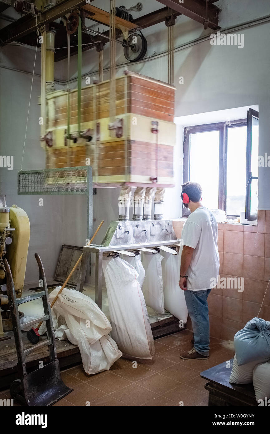 NOCI, Italia - 29 settembre 2018: frumento processo di macinazione in un materiale elettricamente alimentato vecchio mulino Foto Stock