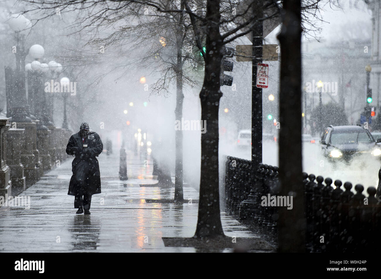 Un uomo cammina sulla 17th Street come la neve e la pioggia inizia a cadere su Marzo 6, 2013 a Washington D.C. Metereologo sono predire ovunque da cinque a dieci centimetri di neve a cadere all'interno del Capital Beltway, e significativamente più ulteriormente a nord e a ovest. UPI/Kevin Dietsch Foto Stock