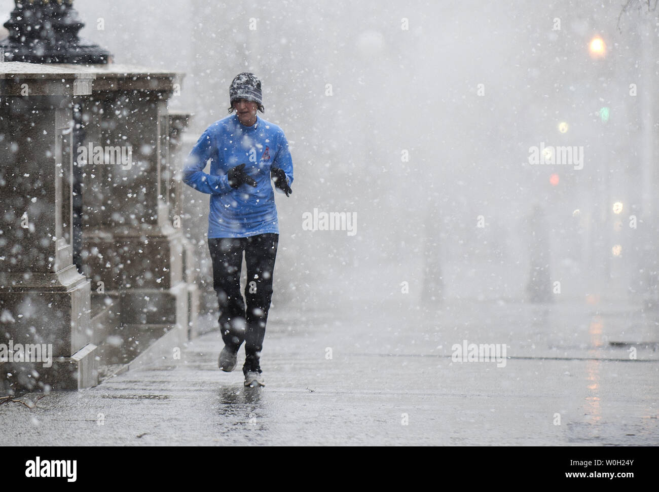 Una donna lavori sulla 17th Street come la neve e la pioggia inizia a cadere su Marzo 6, 2013 a Washington D.C. Metereologo sono predire ovunque da cinque a dieci centimetri di neve a cadere all'interno del Capital Beltway, e significativamente più ulteriormente a nord e a ovest. UPI/Kevin Dietsch Foto Stock