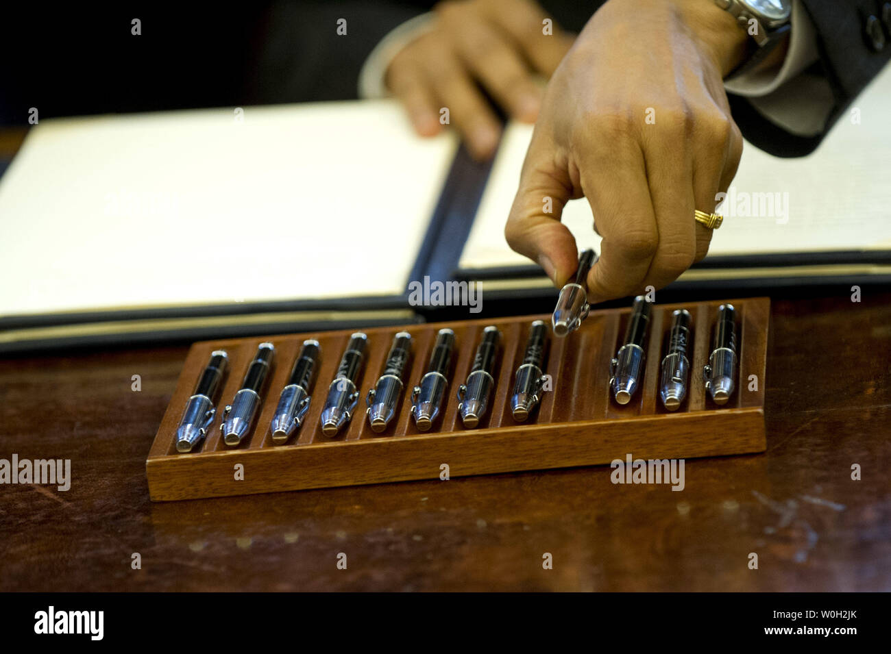 Il presidente Barack Obama raggiunge per una penna come Lui firma un disegno di legge che designa il Rio Grande del Norte, nel Nuovo Messico, monumento nazionale, durante una bolletta firma nell'Ufficio Ovale della Casa Bianca su Marzo 25, 2013 a Washington D.C. Il Presidente Obama ha firmato una serie di progetti di legge che designa cinque nuovi monumenti nazionali, compresi, Rio Grande del Norte, nel Nuovo Messico, il primo membro Monumento Nazionale nel Delaware, The Harriet Tubman Underground Railroad monumento nazionale nel Maryland, il Charles i giovani soldati di Buffalo Naitonal monumento in Ohio e il San Juan Islands National Memorial a Washington. UPI/K Foto Stock