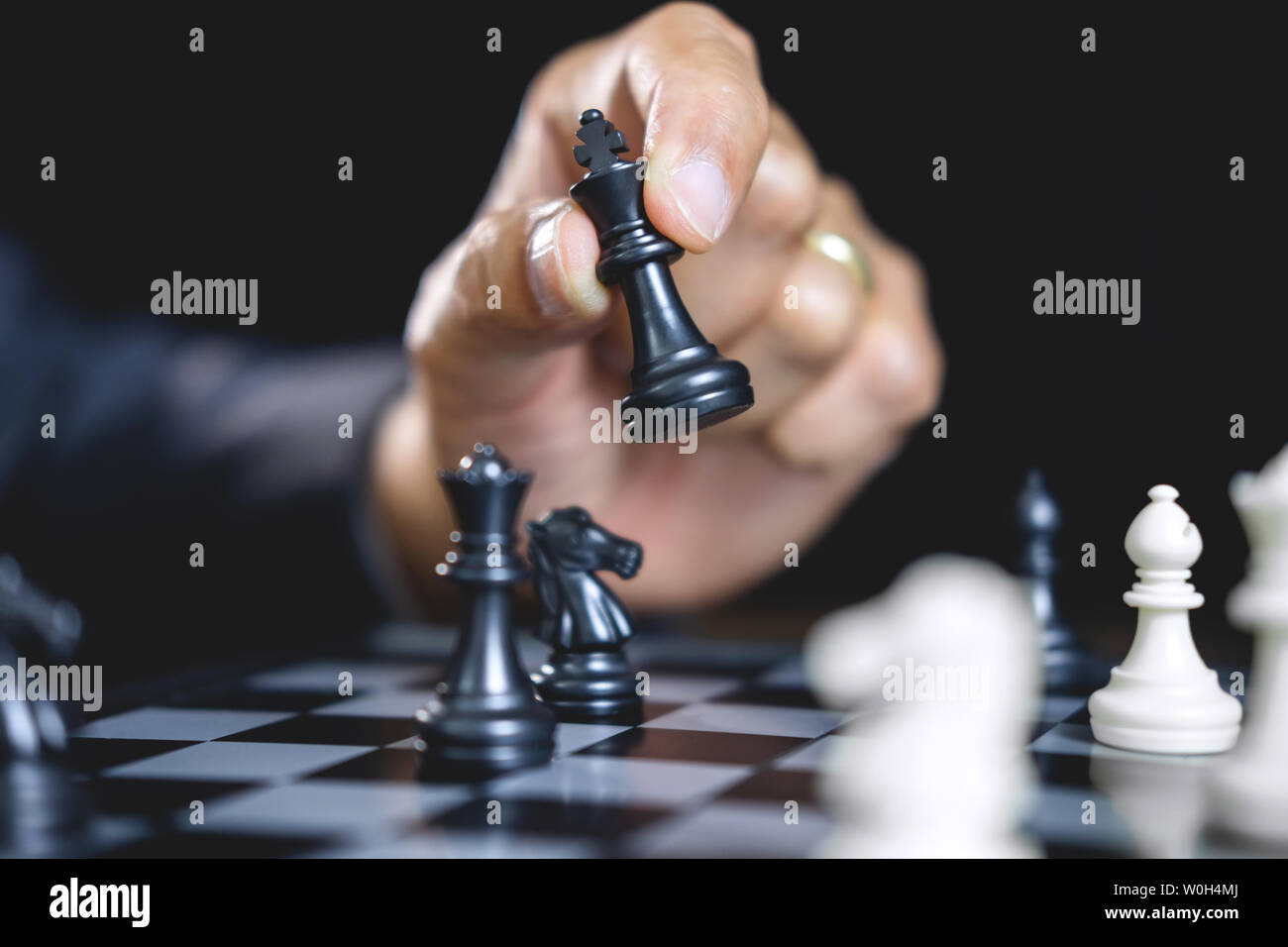 Imprenditore giocando a scacchi e strategia di pensiero circa il crash di rovesciare la squadra opposta e analisi di sviluppo per vincere e di successo. Foto Stock