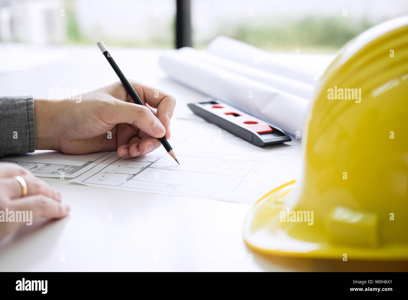 Ingegneria edile o architetto mani lavorando su blueprint ispezione nei luoghi di lavoro, mentre la verifica delle informazioni disegno e schizzi per archita Foto Stock
