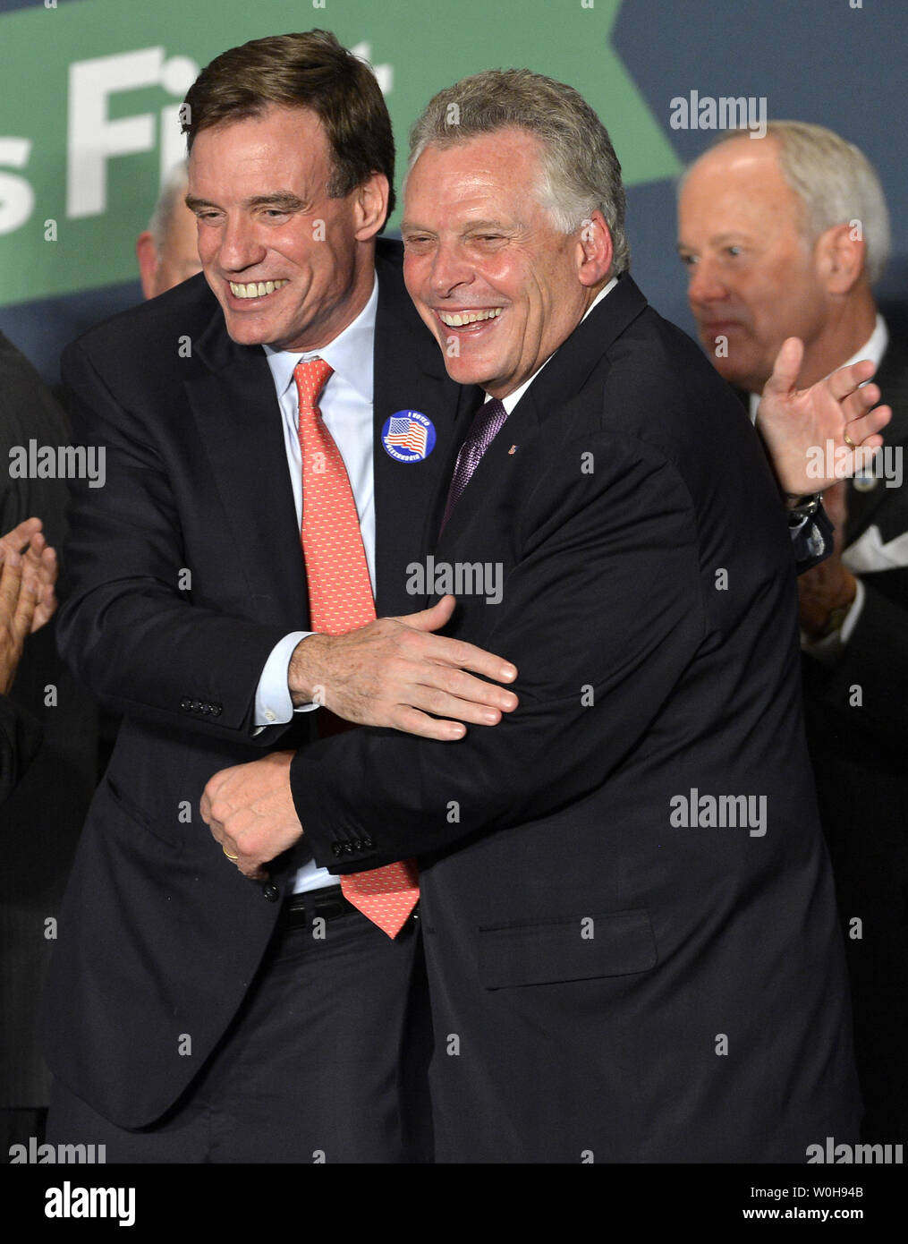 Democratici Terry McAuliffe (R) è abbracciato dal Sen. Mark Warner (D-VA) come egli sostiene la vittoria in Virginia gubernatorial gara durante una celebrazione in Tyson's Corner, Virginia, 5 novembre 2013. McAuliffe ha sconfitto la Virginia Attorney General il repubblicano Ken Cuccinelli in una gara strettamente sorvegliati dal resto del paese. UPI/Mike Theiler Foto Stock