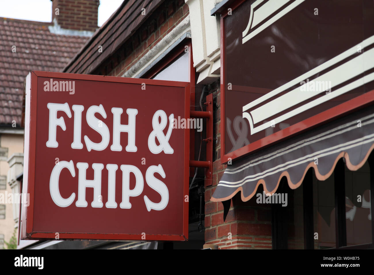 Ashtead, Surrey, Regno Unito - segno per British Fish & Chips, appeso a una parete esterna chip Superfish shop in ore diurne Foto Stock