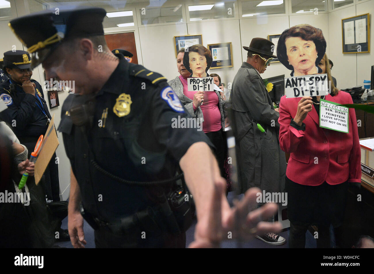 I membri dell'attivista CodePink dimostrazione di gruppo contro il Sen. Dianne Feinstein (D-CA) e ciò che il gruppo sta chiamando il suo "due-di fronte posizione su spionaggio' dentro il suo ufficio del Senato Hart Edificio per uffici a Washington DC, il 12 marzo 2014. UPI/Kevin Dietsch Foto Stock