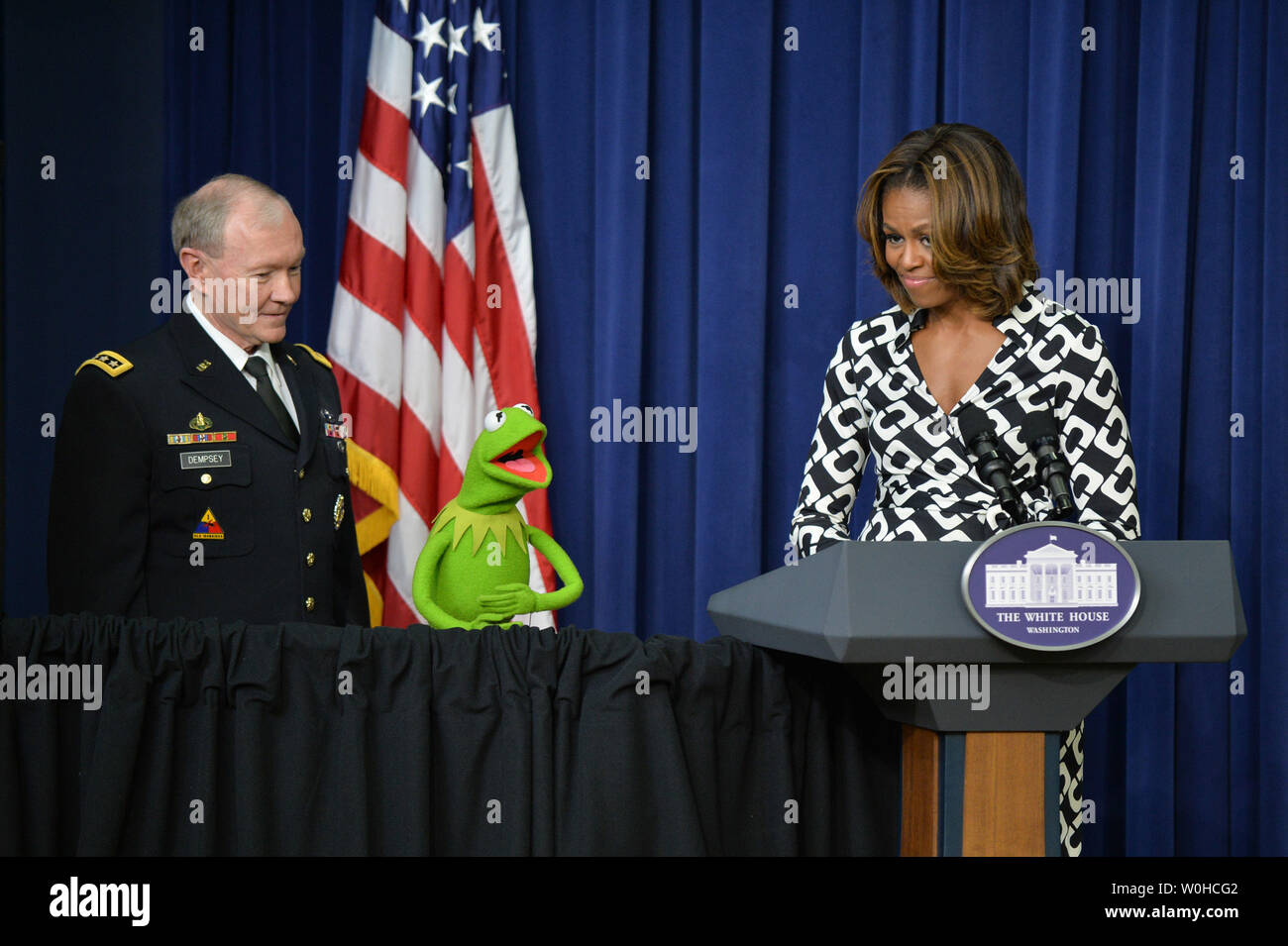 La First Lady Michelle Obama, Kermit la rana e il presidente del Joint Chiefs gen. Martin Dempsey offrono commento prima di un filmato lo screening di 'Muppets Most Wanted' per i bambini di famiglie di militari a Eisenhower Executive Office Building a Washington DC, il 12 marzo 2014. UPI/Kevin Dietsch Foto Stock