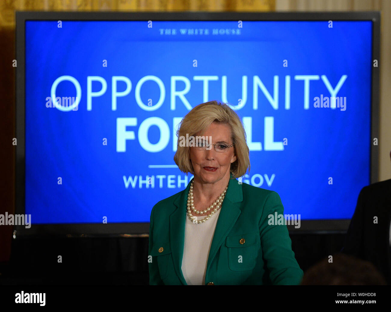 La parità di retribuzione attivista Lilly Ledbetter cammina davanti a un monitor che dice "Opportunità per Tutti" prima che il Presidente Barack Obama ha firmato due ordini esecutivi in materia di parità di retribuzione per le donne in occasione di un evento nella Sala Est della Casa Bianca a Washington il 8 aprile 2014. Obama ha firmato la Lilly Ledbetter Fair Pay Act del 2009, e gli Stati Uniti Il senato discuterà la busta paga equità atto di domani. UPI/Pat Benic Foto Stock