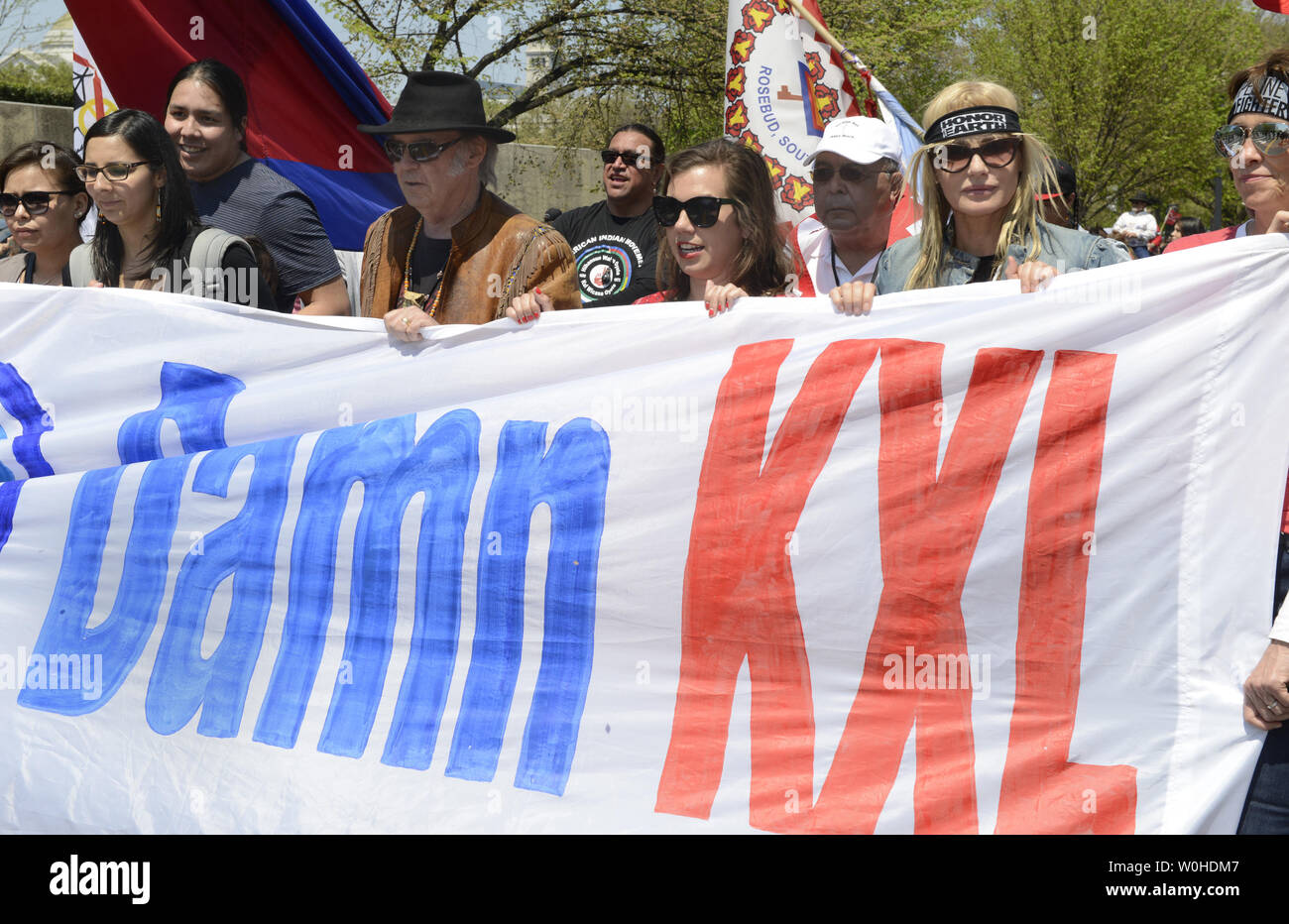 Rock Star Neil Young (indossando hat) e attrice e attivista Daryl Hannah (R) unire dimostranti durante una manifestazione organizzata dal Cowboy coalizione indiano (CIA) per protestare contro la costruzione del Keystone XL pipeline, 26 aprile 2014, a Washington, DC. Allevatori e agricoltori, i nativi americani e gli ambientalisti stanno invitando il Presidente Obama a respingere la pipeline. UPI/Mike Theiler Foto Stock