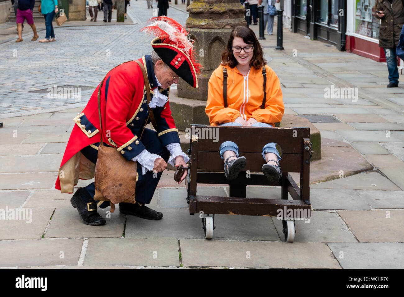 CHESTER, Regno Unito - 26 giugno 2019: Il town crier blocca un turista in un stockade nel centro della città, estate 2019 Foto Stock