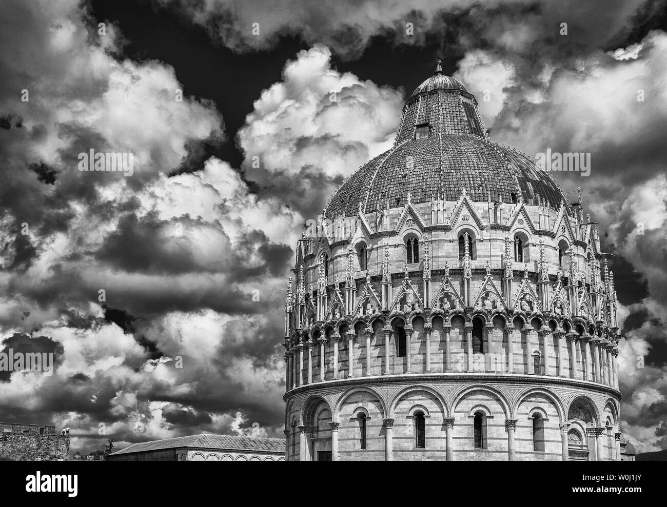 Battistero di Pisa medievale con cupola di nuvole e città antiche mura (bianco e nero) Foto Stock
