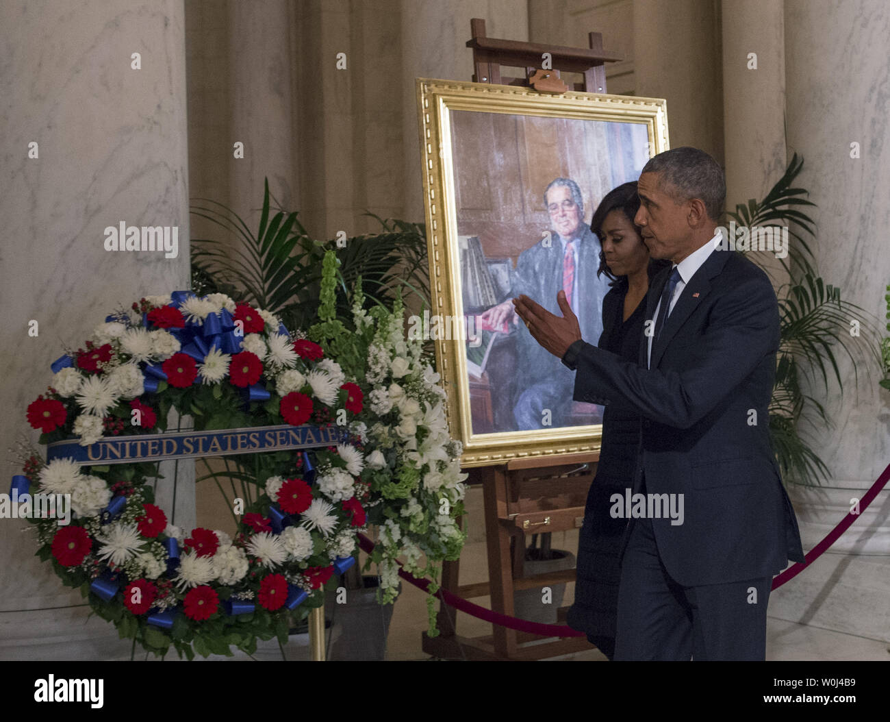 Il presidente Barack Obama e la first lady Michelle passano da un dipinto di U.S. Giudice della Corte suprema Antonin Scalia come essi pagare rispetta la giustizia come egli si trova a riposo nella grande sala della corte suprema a Washington DC, 19 febbraio 2016. Foto di Molly Riley/UPI Foto Stock