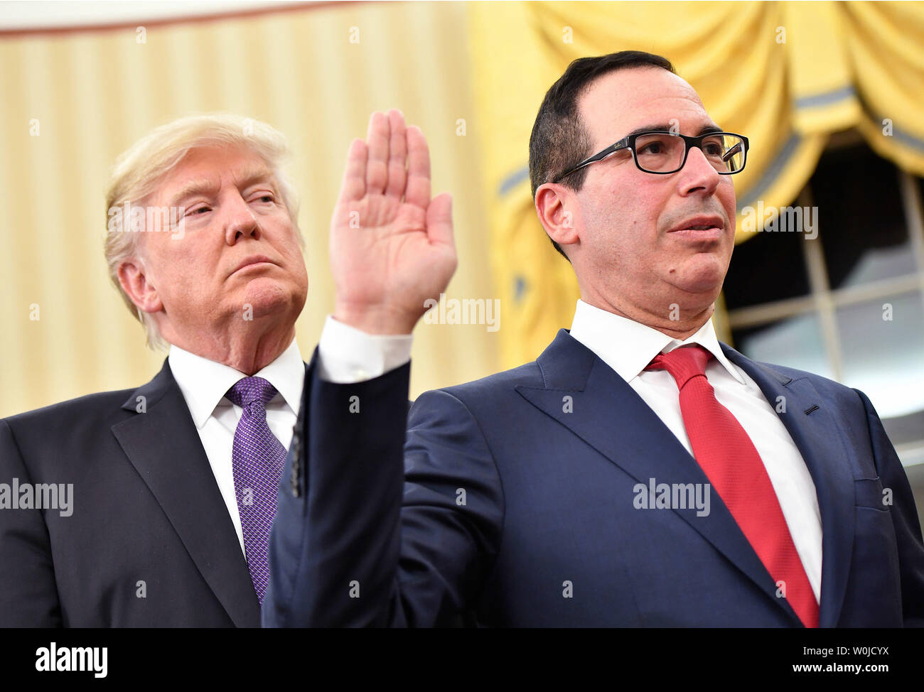 Presidente Donald Trump guarda oltre lo spallamento del Segretario del Tesoro, Steven Munchin come egli è giurata-in nel corso di una cerimonia alla Casa Bianca a Washington D.C. il 13 febbraio 2017. Mnuchin è stata confermata dal Senato 54-47 prima di oggi. Foto di Kevin Dietsch/UPI Foto Stock