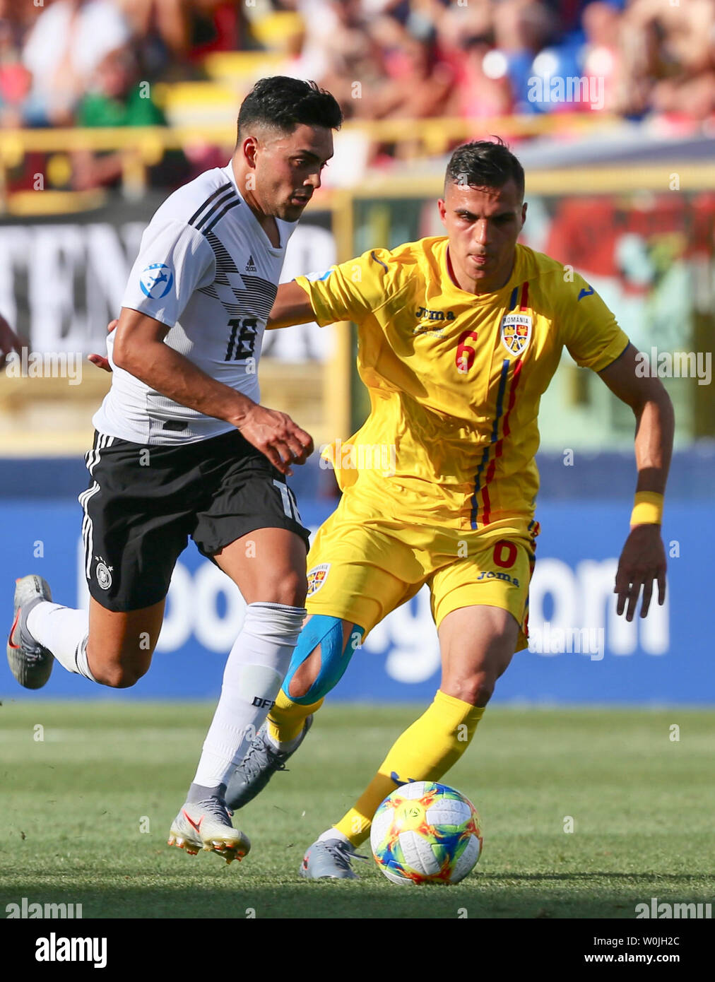 Bologna, Italia. Il 27 giugno, 2019. Soccer, U-21 uomini: Campionato Europeo, Germania - Romania, ultimo round, semi-finale: Nadiem Amiri (l) dalla Germania segnerà il primo obiettivo della sua squadra contro Cristian Manea dalla Romania. Credito: Cezaro De Luca/dpa/Alamy Live News Foto Stock