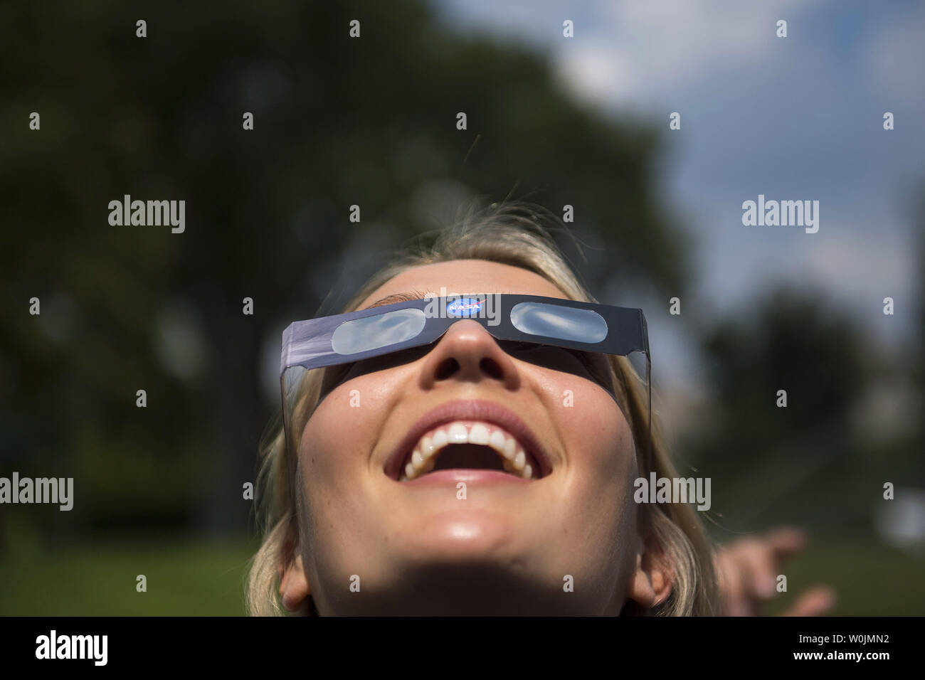 Un membro della Casa Bianca il personale indossa speciali occhiali solare come lei viste le eclissi solare dalla Casa Bianca a Washington D.C., il 21 agosto 2017. Foto di Kevin Dietsch/UPI Foto Stock