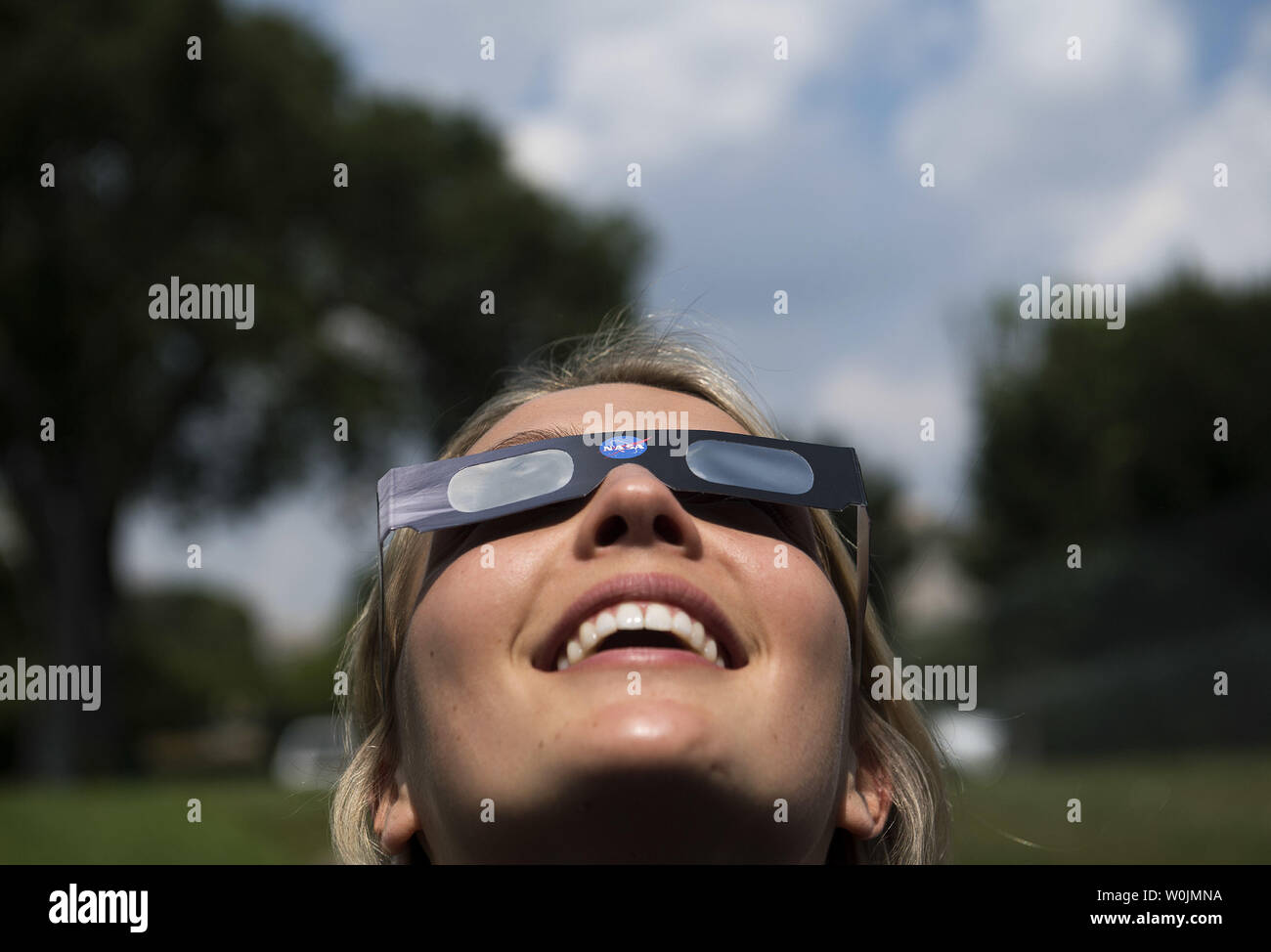 Un membro della Casa Bianca il personale indossa speciali occhiali solare come lei viste le eclissi solare dalla Casa Bianca a Washington D.C., il 21 agosto 2017. Foto di Kevin Dietsch/UPI Foto Stock