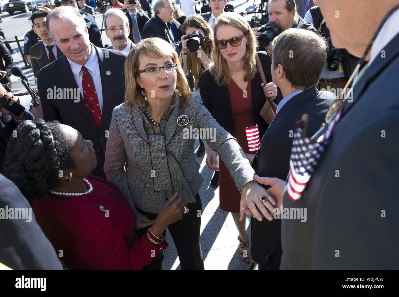 Ex congressista e della violenza pistola vittima Gabby Giffords (C) saluta i membri del Congresso a seguito di un rally sulla parte anteriore orientale passi dell'U.S. La camera dei rappresentanti il 4 ottobre 2017 a Washington D.C. I deputati democratici del Congresso tenuto il rally per onorare le vittime della massa riprese in Las Vegas e la richiesta di passaggio del King-Thompson bipartisan normativa per rafforzare i controlli in background e che istituisce una bipartisan Comitato di selezione sulla violenza pistola. Foto di Kevin Dietsch/UPI Foto Stock