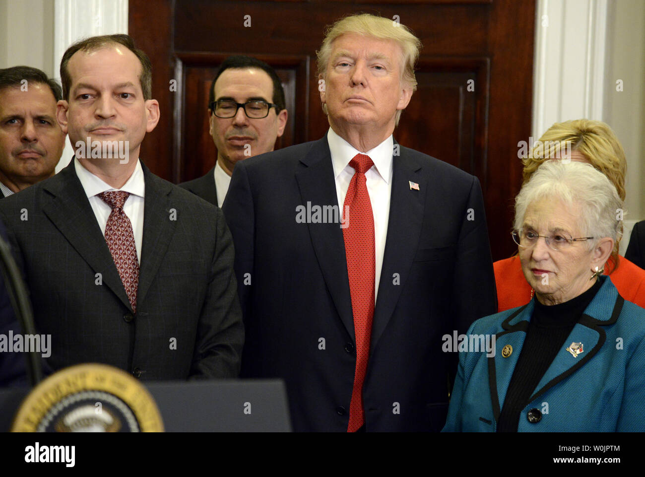 Presidente Donald Trump (C) ascolta le osservazioni di apertura lungo con sost. Virginia Foxx della Carolina del Nord (R), segretario del Lavoro Alex Acosta (L) e segretario del Tesoro Steven Mnuchin (dietro Trump), prima di Trump firma un ordine esecutivo sulla sanità, nella sala Roosevelt della Casa Bianca, 12 ottobre 2017, a Washington, DC. L'ordine potrà offrire alternative alla cura conveniente agire, anche chiamato Obamacare, dopo Congressional piani erano in fase di stallo. Foto di Mike Theiler/UPI Foto Stock