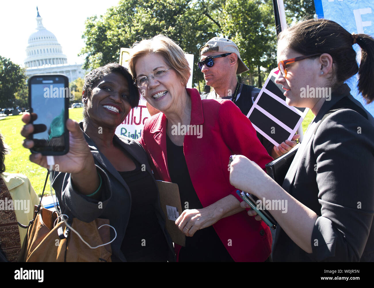 Il Sen. Elizabeth Warren, D-MA, saluta un manifestante a una protesta chiamando il Congresso e la Casa Bianca per un piano di ripristino e di recupero per il pacchetto alle vittime dell uragano di Puerto Rico e altre aree dismesse dagli uragani Irma, Maria e Harvey, sulla Capitol Hill a Washington D.C., il 18 ottobre 2017. Foto di Kevin Dietsch/UPI Foto Stock