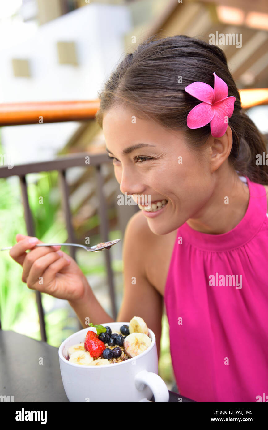 Acai bowl - ragazza di mangiare cibo sano all'esterno. Donna godendo di acai bocce realizzato da acai bacche e frutti all'aperto per la prima colazione. Foto Stock