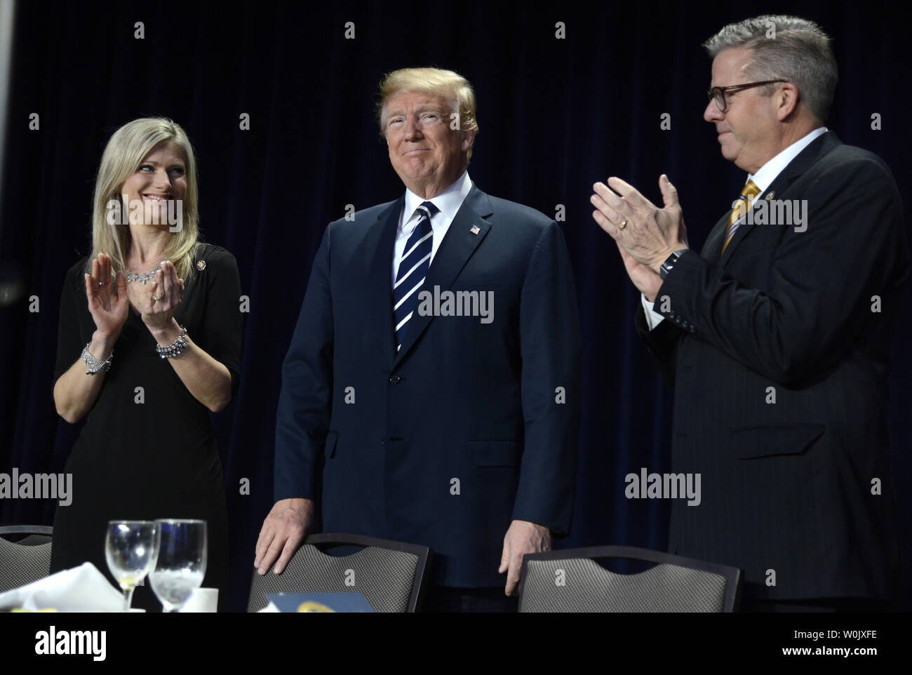 Presidente Donald Trump (C) accetta applausi da Illinois sost. Randy Hultgren (R) e sua moglie Christy come egli arriva per la National Prayer Breakfast, 8 febbraio 2018, a Washington, DC. Migliaia di persone da tutto il mondo frequentano l annuale incontro ecumenico e ogni presidente dal Presidente Dwight Eisenhower ha affrontato l'evento. Foto di Mike Theiler/UPI Foto Stock