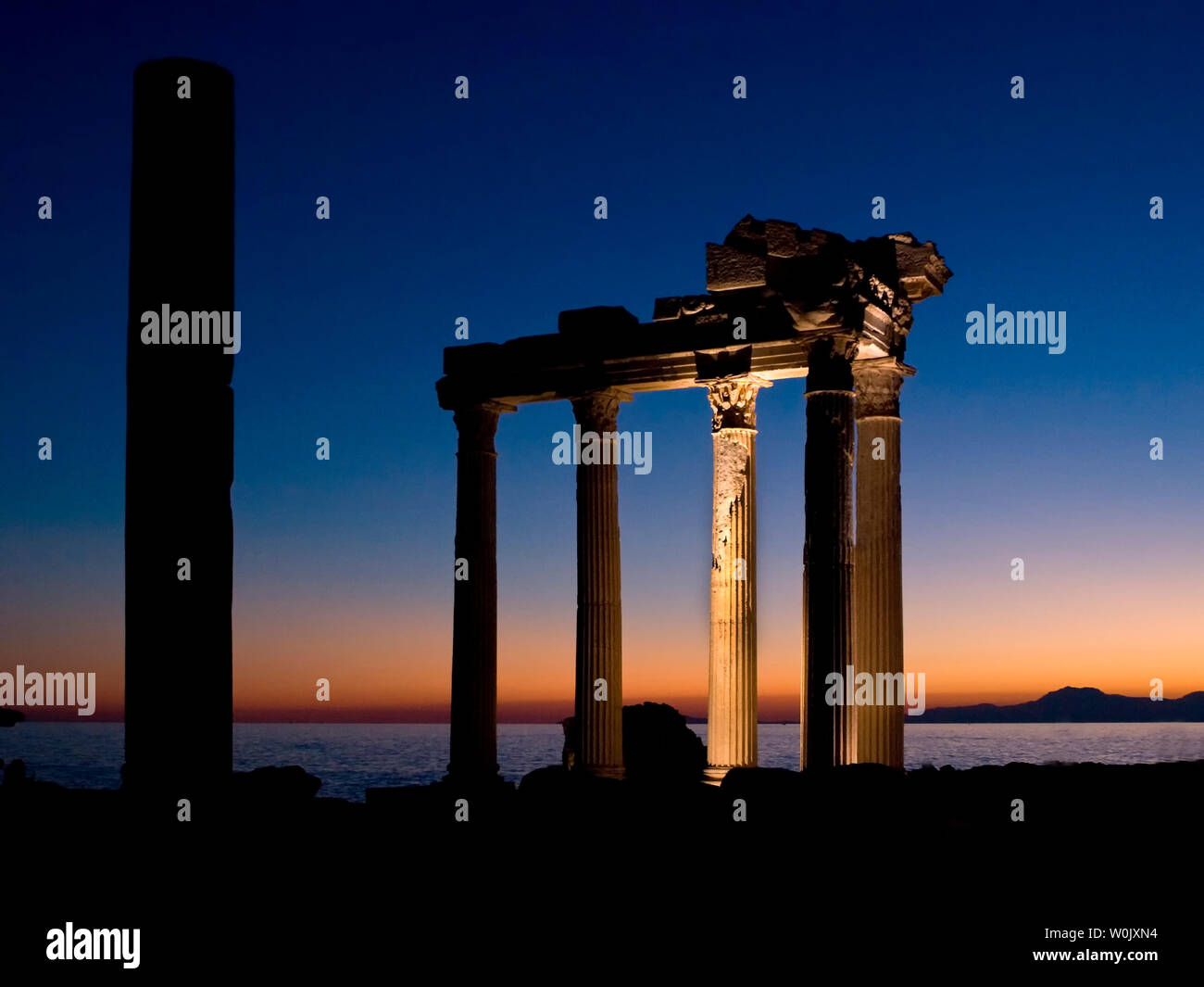 I resti del tempio di Apollo a lato sulla costa meridionale della Turchia. Mostra i resti come il sole sta tramontando nel Mediterraneo. Foto Stock