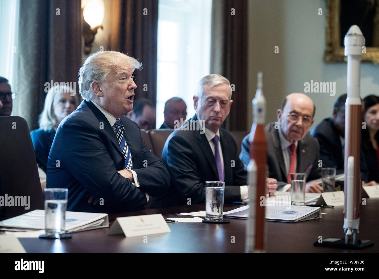 Il presidente statunitense Trump parla accanto il Segretario alla difesa degli Stati Uniti Jim Mattis (C) e US Commerce Segretario Wilbur Ross (R), con modelli di razzo visto sul tavolo, durante un incontro con i membri della Trump armadietto, in Cabinet Room della Casa Bianca di Washington, D.C. Marzo 8, 2018. Foto di Michael Reynolds/UPI Foto Stock