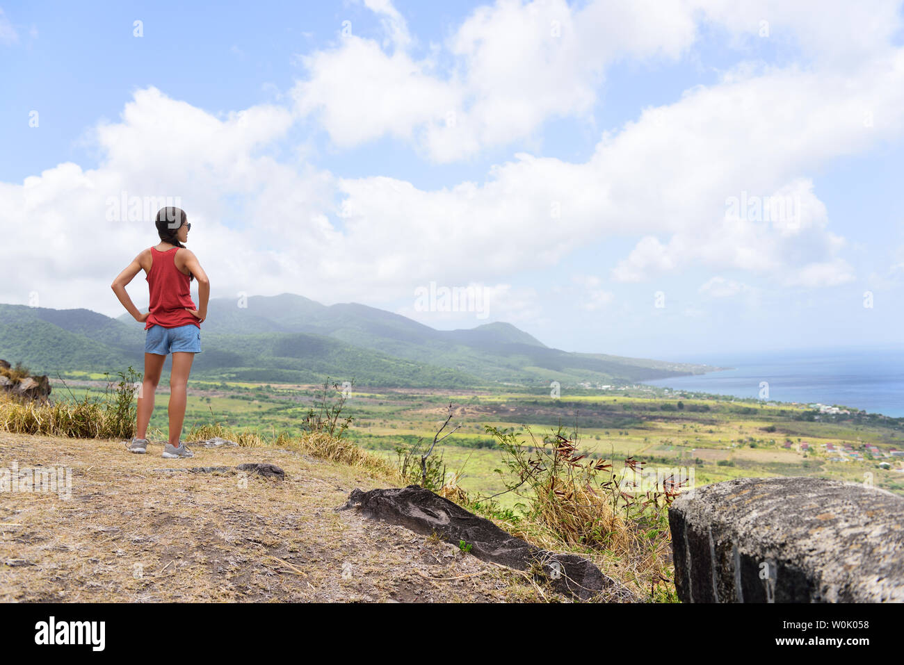 Escursionismo donna sul viaggio escursione durante la crociera di vacanza guardando a St Kitts e Nevis paesaggio. Caraibi la natura durante le vacanze estive. Giovane ragazza in piedi a Lookout guardando viewpoint. Foto Stock