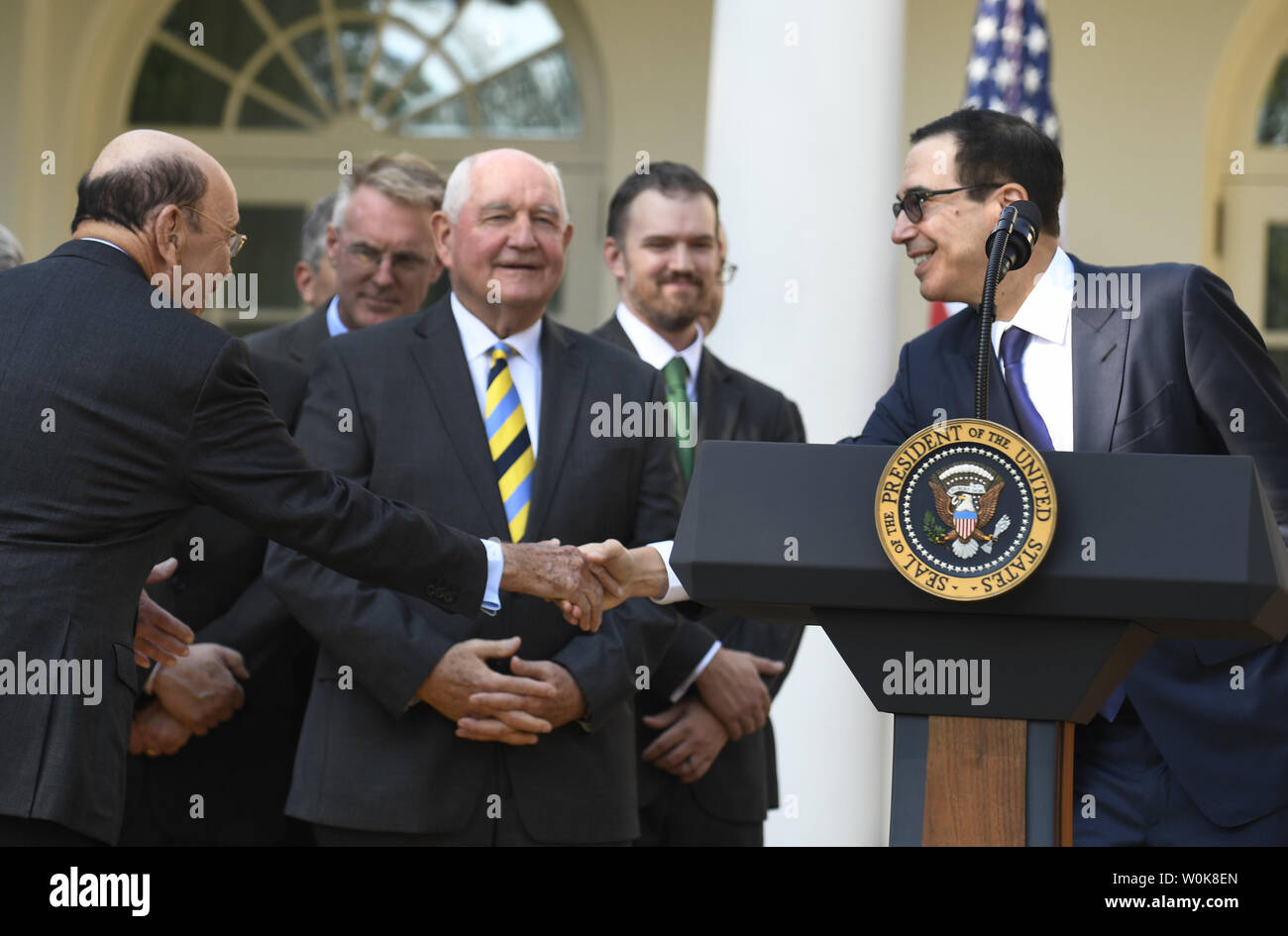 Il segretario del commercio Wilbur Ross (L) stringe la mano con il Segretario al Tesoro Steven Mnuchin come segretario per l'agricoltura Sonny Perdue orologi, come li attendono l arrivo del presidente Donald Trump's annuncio su Stati Uniti Messico Canada accordo (USMCA) nel Giardino delle Rose della Casa Bianca, 1 ottobre 2018, a Washington, DC. Il trilaterale USMCA patto commerciale sostituirà l'Accordo nordamericano di libero scambio (NAFTA) del 1994. Foto di Mike Theiler/UPI Foto Stock