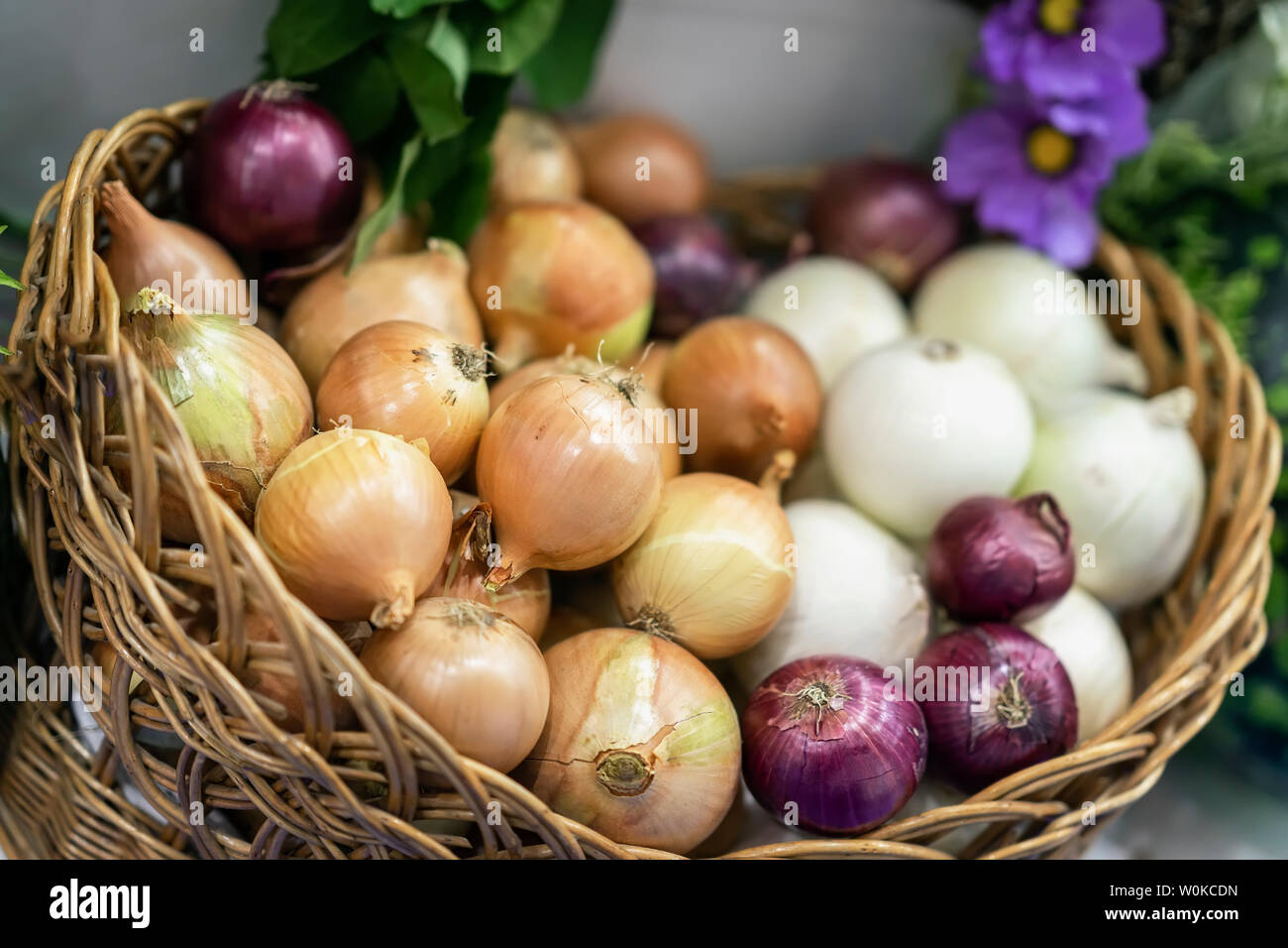 Un assortimento di cipolle di varietà diverse. Cestello con fresche verdure organiche, Live vitamine, selectiv focus. Mercato degli Agricoltori Foto Stock