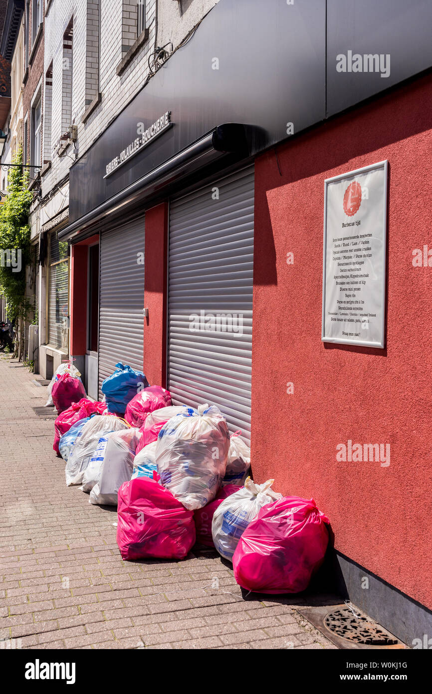 Bianco, blu e rosa sacchi per i rifiuti in attesa di raccolta - Bruxelles, Belgio. Foto Stock