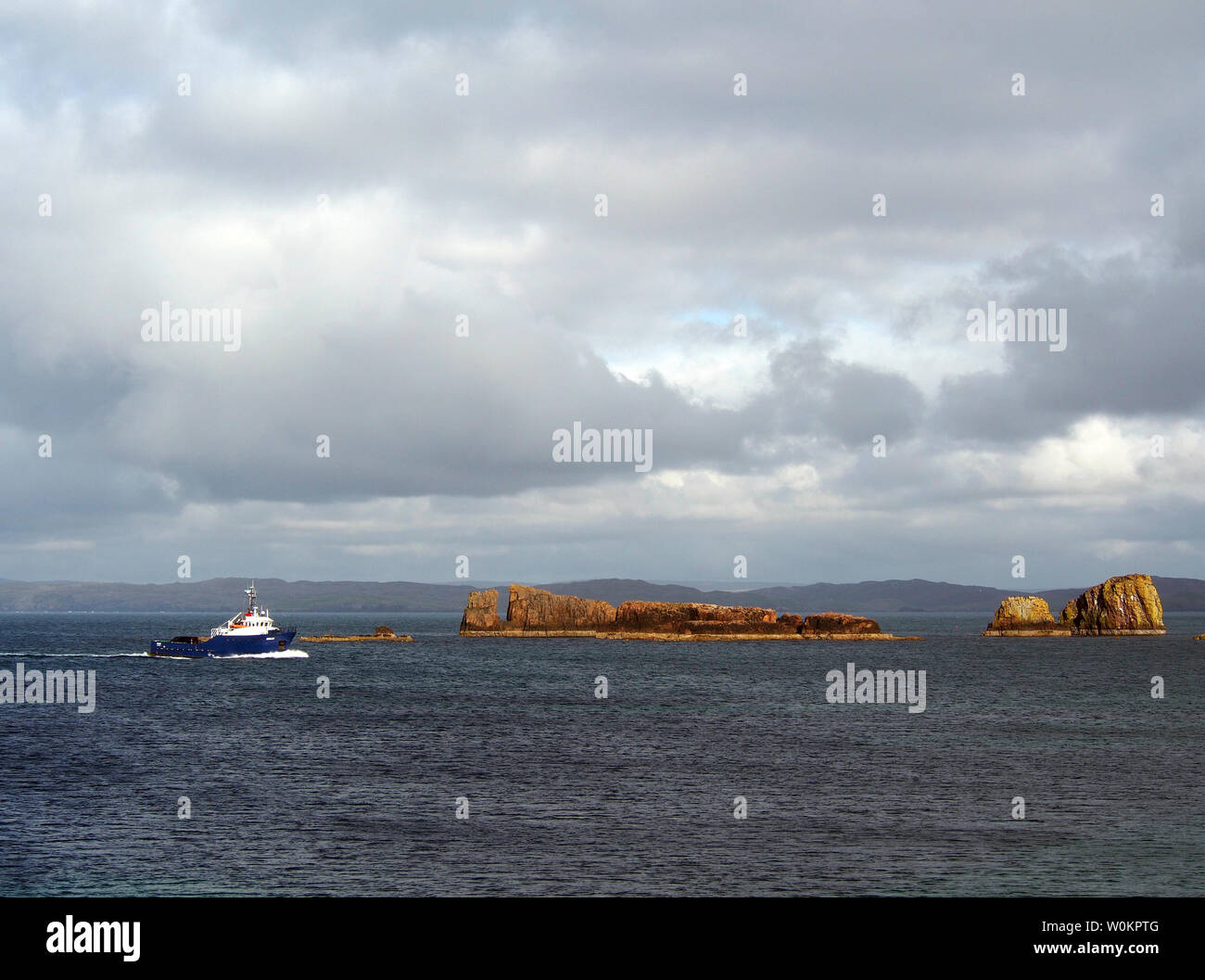 Il traghetto passa Maiden stack e altre pile off lungo la costa orientale del Papa Stour, Shetland Foto Stock