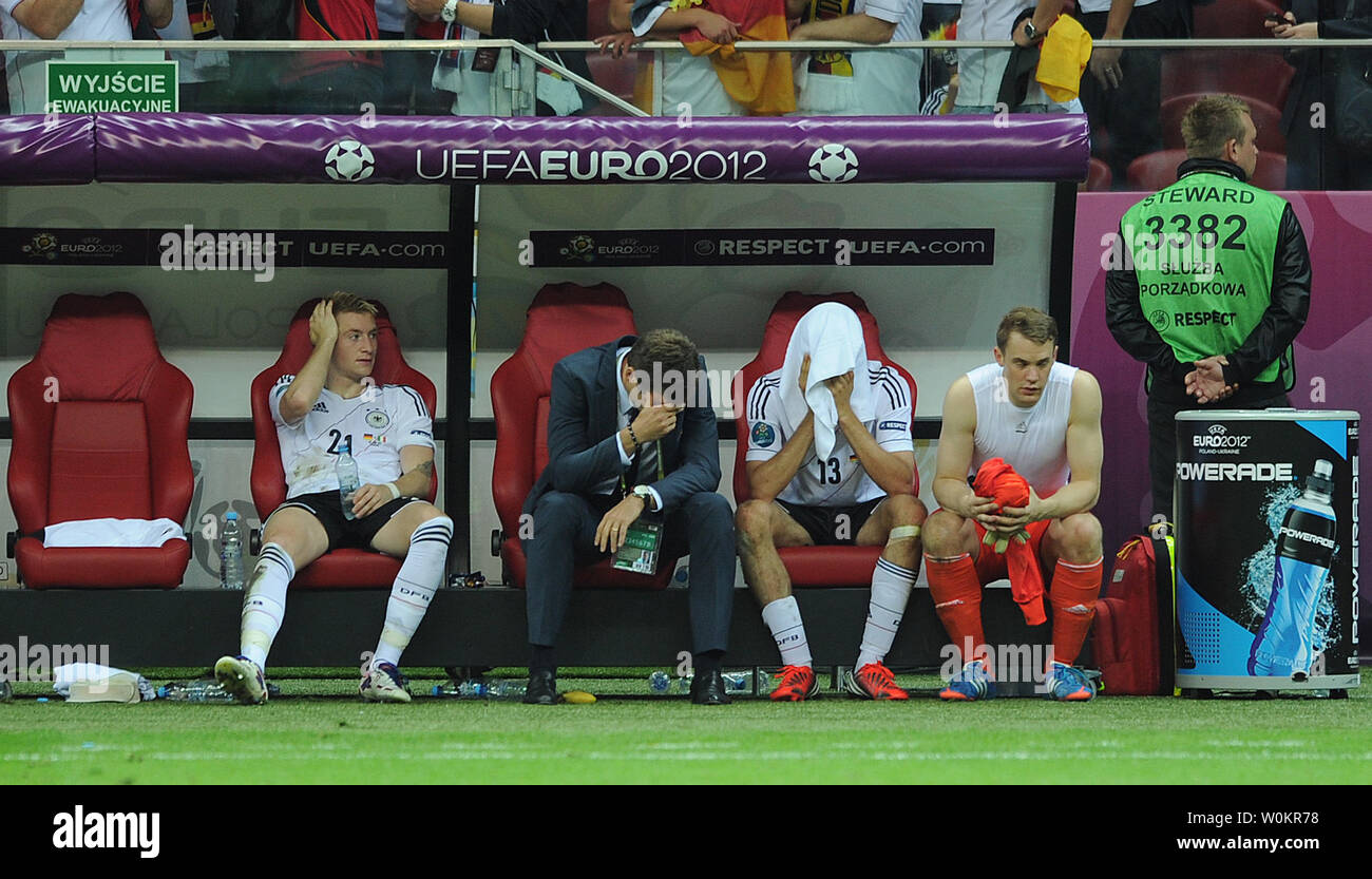 Oliver Bierhoff e Thomas Muller (C) sguardo sconsolato sul banco in seguito l'Euro 2012 Semi-Final match presso lo Stadio Nazionale di Varsavia, Polonia, il 28 giugno 2012. UPI/Chris Brunskill Foto Stock